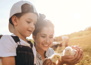 Child and woman holding yellow chicks